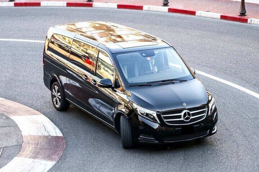 A black Mercedes-Benz van with a gold reflective surface parked on a road. 4