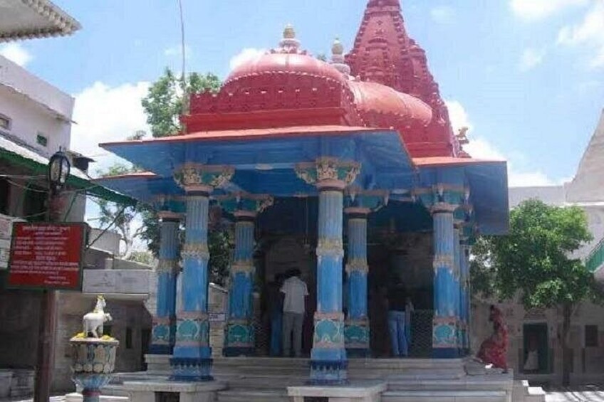 A temple with a red dome and blue pillars. 4