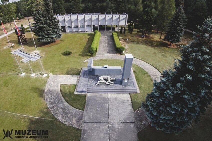 A museum with a central sculpture, surrounded by a well-maintained lawn and trees. 5