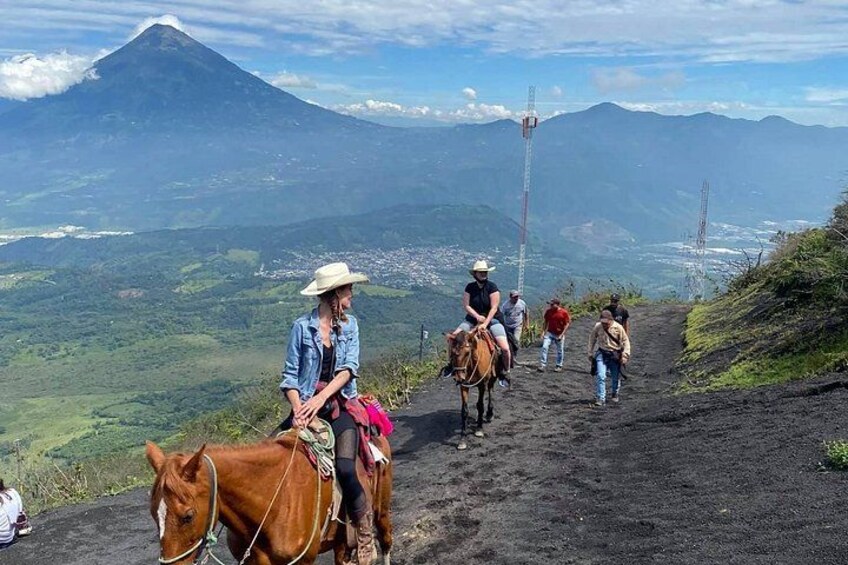A group of people on a dirt path with a mountain in the background. 1