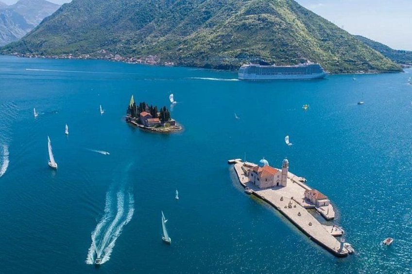 A coastal area with a cruise ship, sailboats, and a small island with buildings. 3