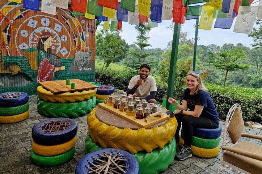 A colorful outdoor seating area with a mural, a table with drinks, and a scenic background. 5