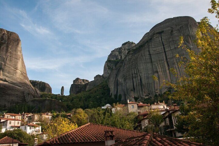 A town nestled between large rock formations with traditional buildings and a clear sky. 3