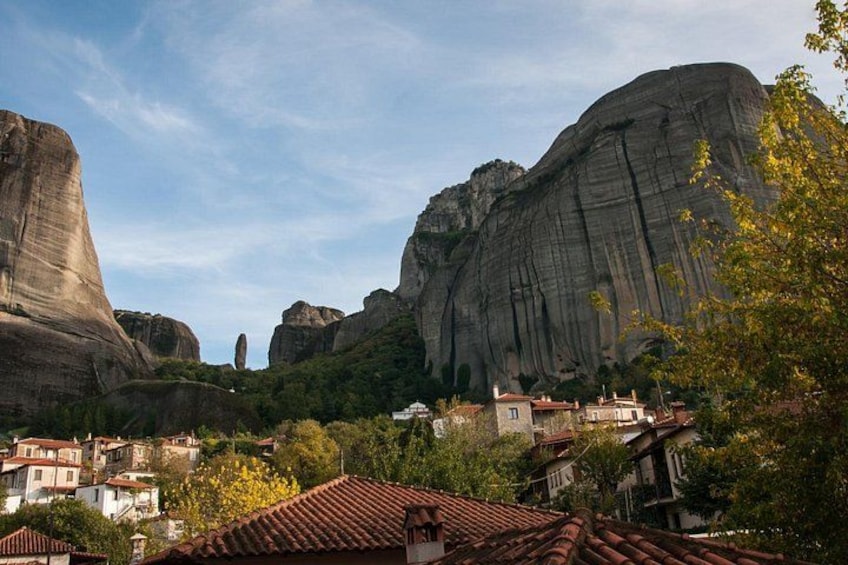 A town nestled between large rock formations with traditional buildings and a clear sky. 3