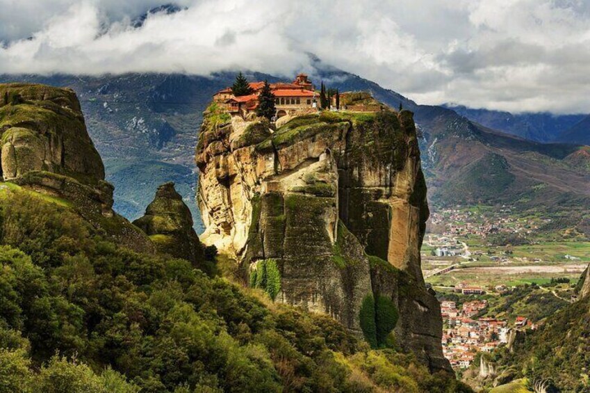 A monastery on a rocky cliff with a town below. 1