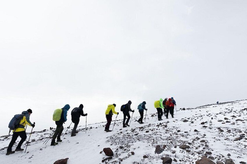 A group of hikers ascending a snowy mountain. 3