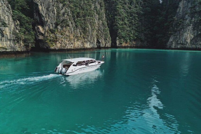 Un bote sobre aguas turquesas, con un acantilado rocoso al fondo. 4