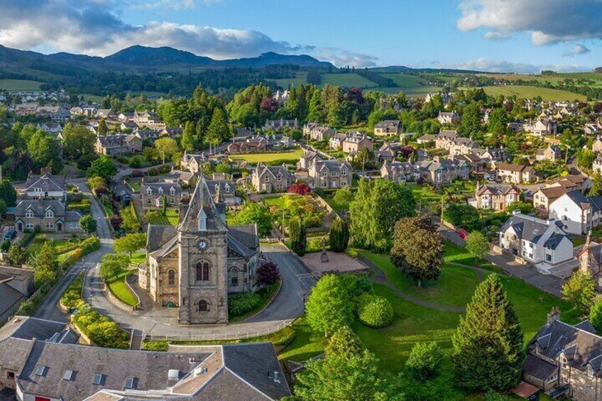 A town with a prominent church, residential houses, and surrounding greenery. 2