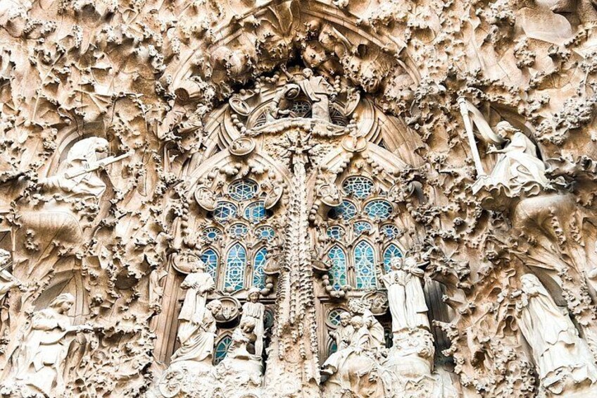 A detailed architectural facade with ornate carvings and a prominent arched window. 2