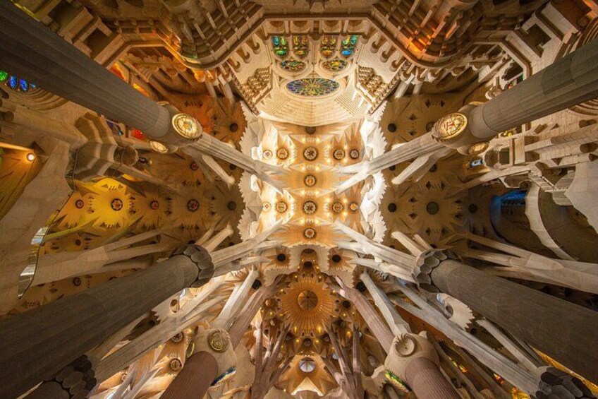 A grand architectural interior with intricate ceiling designs, large columns, and stained glass windows. 4