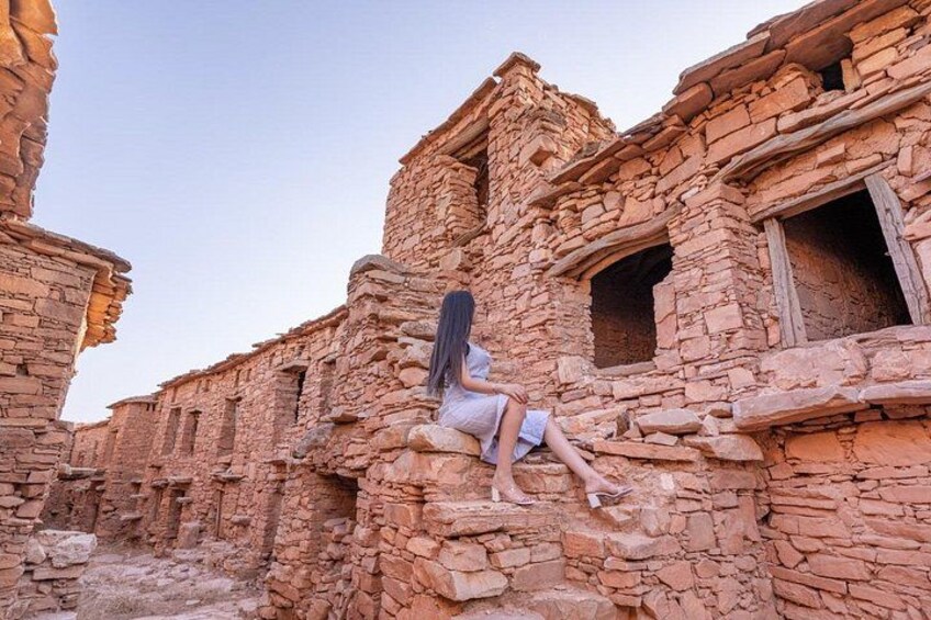 A person sitting on a stone wall of an ancient ruin. 3
