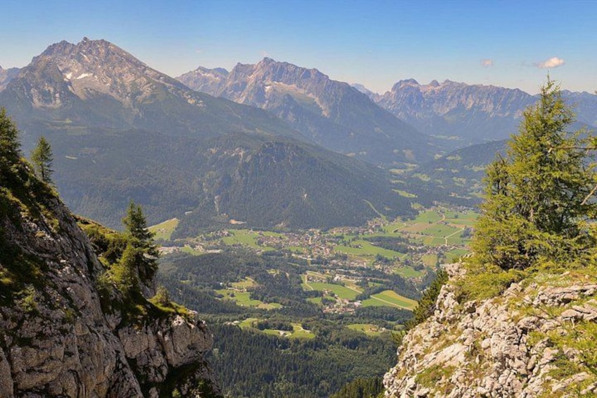A mountainous landscape with a valley, rocky outcrops, and coniferous trees. 5