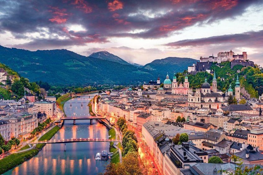 A cityscape with a river, a bridge, and a castle on a hill. 1