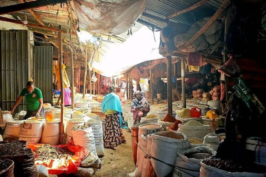 A market with people shopping and vendors selling goods. 1