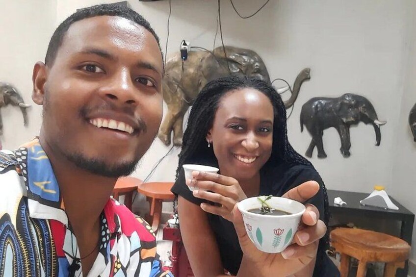 Two people holding a cup, with decorative animal figures on the wall. 3