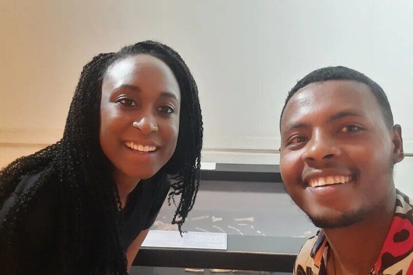 Two people sitting indoors with a window in the background. 5