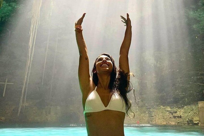 Una persona con traje de baño en una piscina con una cascada al fondo. 5