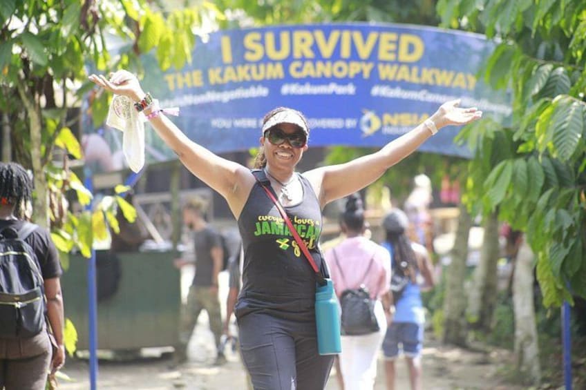 A person with arms raised, wearing a tank top with 'Jamaica' written on it, and a blue water bottle. 5