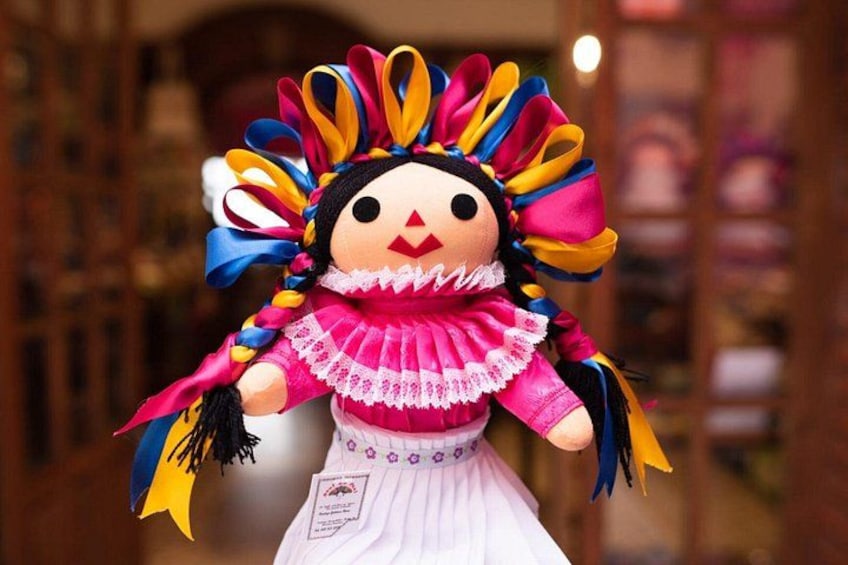 A colorful doll with a pink dress and a multicolored headdress. 5
