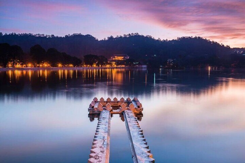Un molo di legno che si protende in un lago calmo al crepuscolo, con una montagna sullo sfondo. 2