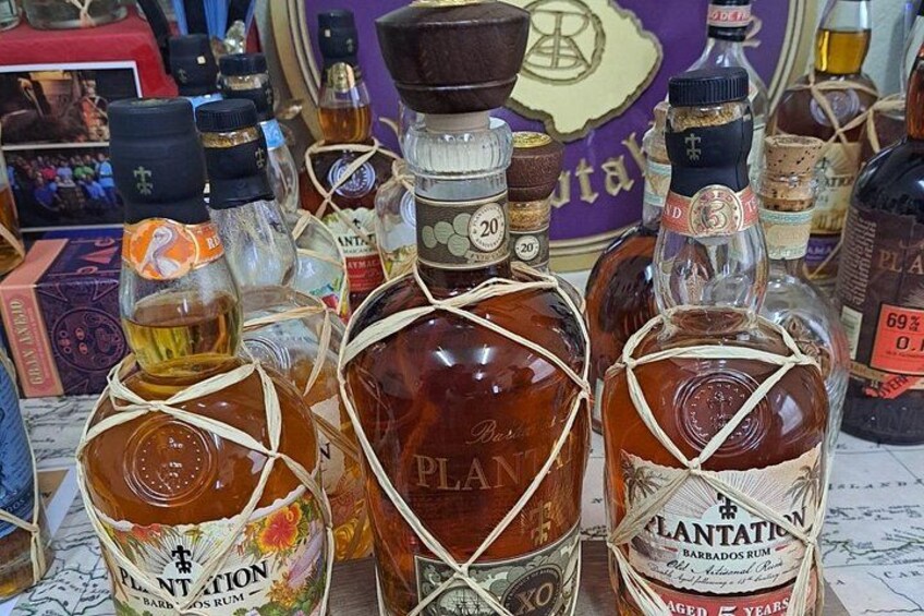 Diverse flessen rum en andere sterke drank, sommige met etiketten en andere met kurken. 5