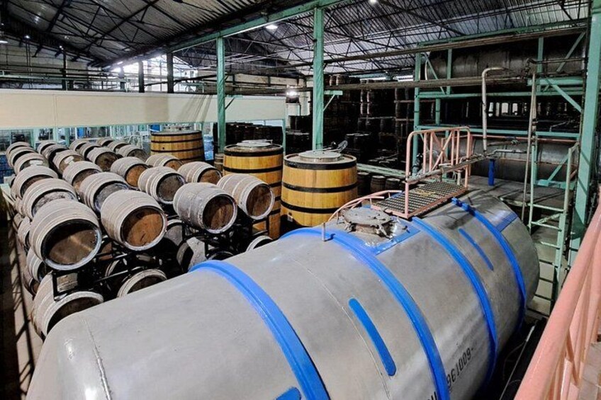 Large industrial tanks and wooden barrels in a warehouse. 2