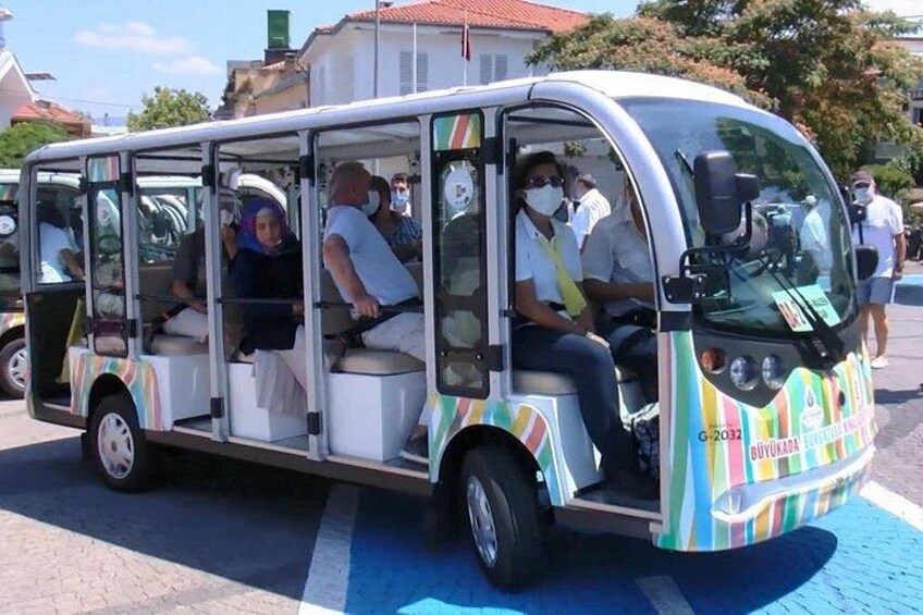 A colorful bus with passengers, parked on a street with blue lines. 2