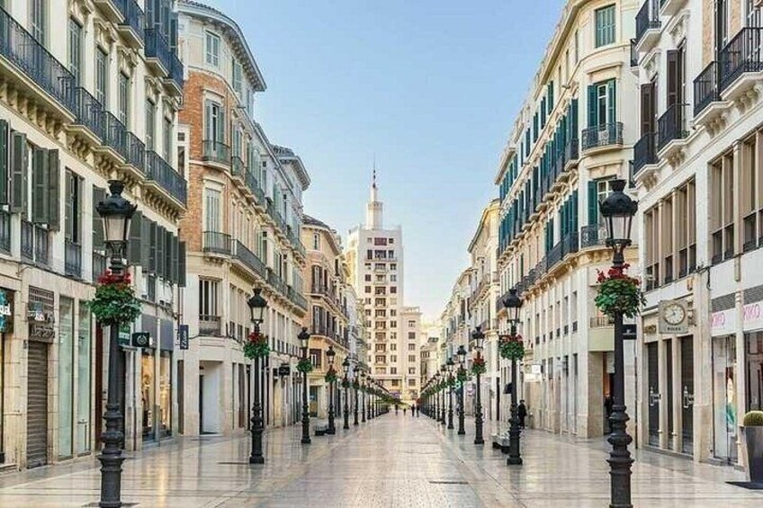 Una amplia avenida arbolada con edificios históricos, un rascacielos distante y farolas decorativas. 2