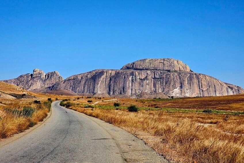 A road leading to a large rock formation. 3