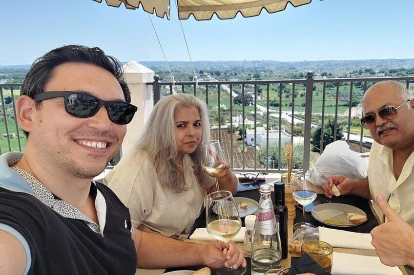 A group of people sitting at an outdoor table with a scenic view in the background. 3