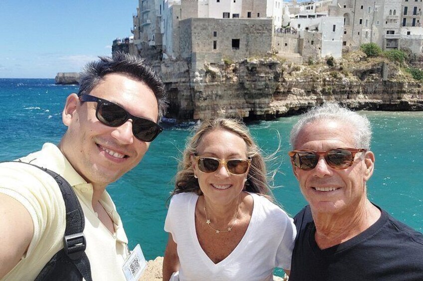 Three people taking a selfie with a coastal town and cliffs in the background. 4
