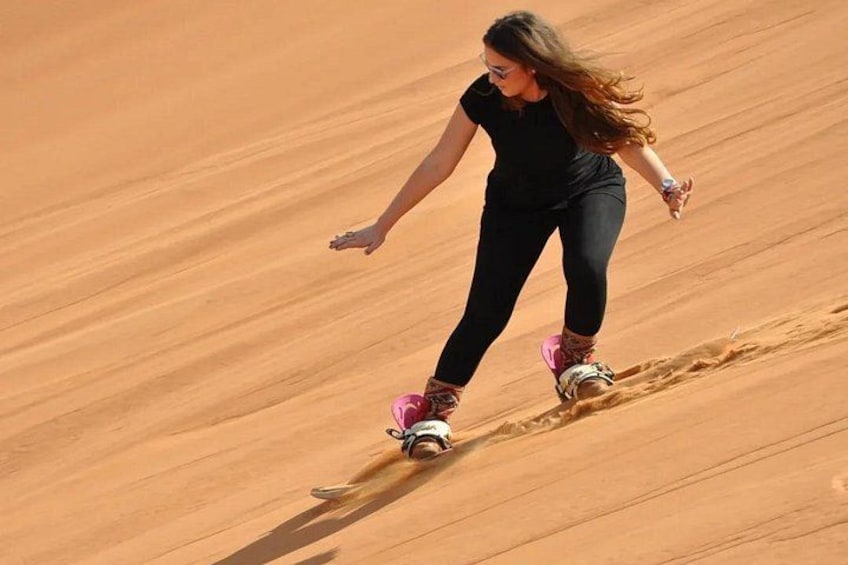 A person riding a dune buggy on a sandy dune. 5