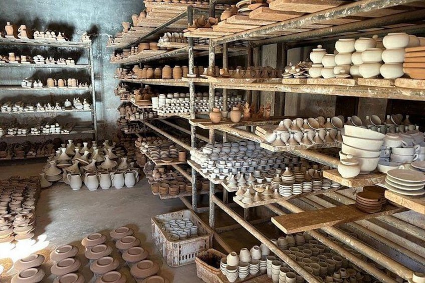 A pottery workshop with shelves filled with various ceramic items. 3