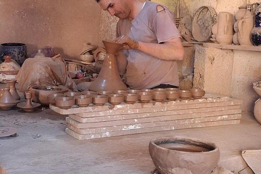 A person working with pottery in a workshop. 2