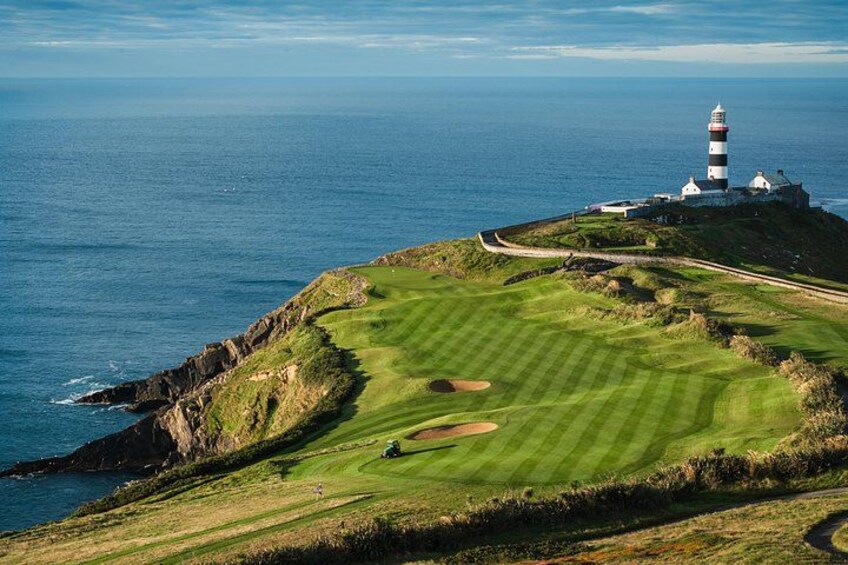 Un parcours de golf situé sur la côte, avec un phare en arrière-plan. 5