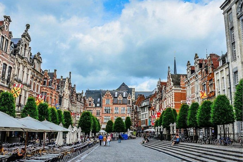 A cobblestone street lined with historic buildings, trees, and bicycles. 4