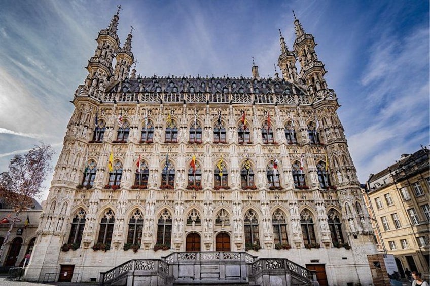 A historic building with intricate architecture, multiple windows, and flags. 1