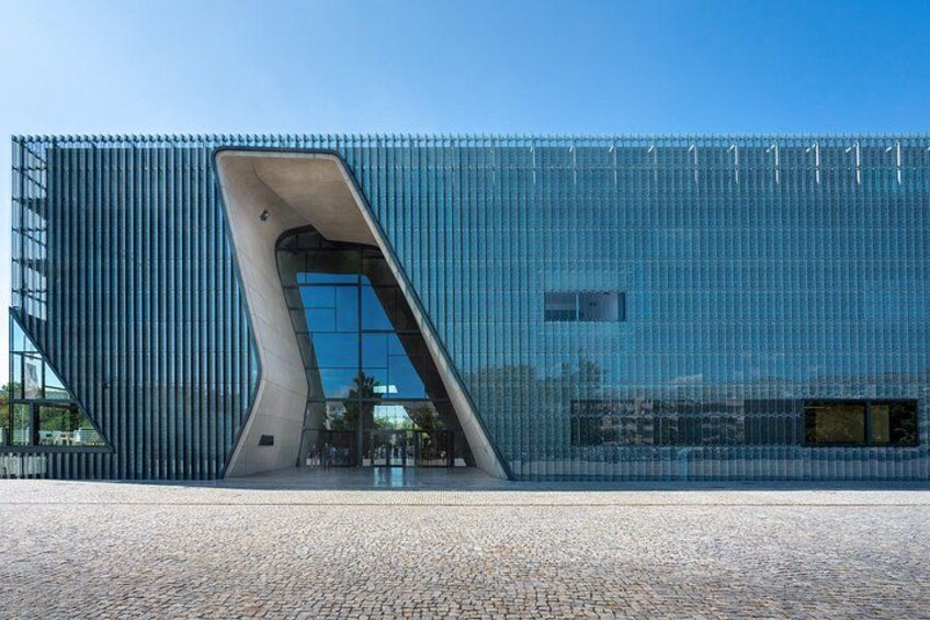 Un bâtiment moderne doté d’une entrée à l’architecture originale et d’une façade en verre réfléchissant. 3