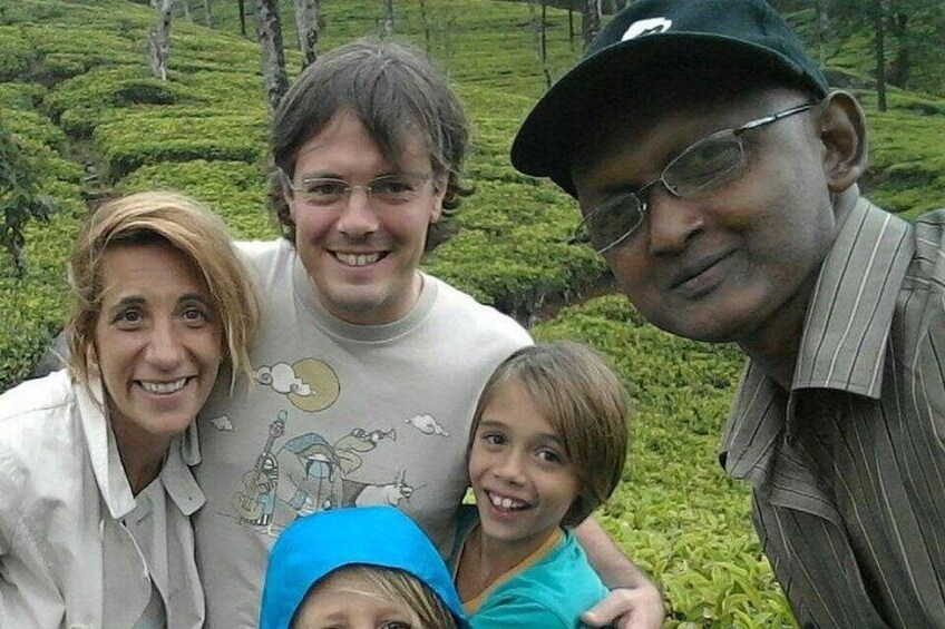 A family of four in a lush green tea plantation. 4