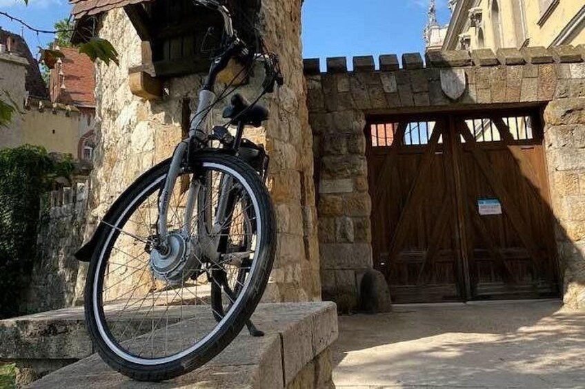 Un vélo appuyé contre un mur de pierre, une porte en bois et un bâtiment avec un toit en tuiles. 5