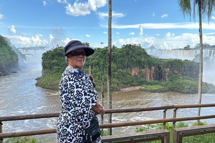 Una persona de pie junto a una barandilla con vista a una cascada. 5