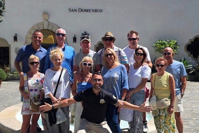 A group of people posing in front of a building with the inscription 'SAN DOMENICO'. 1