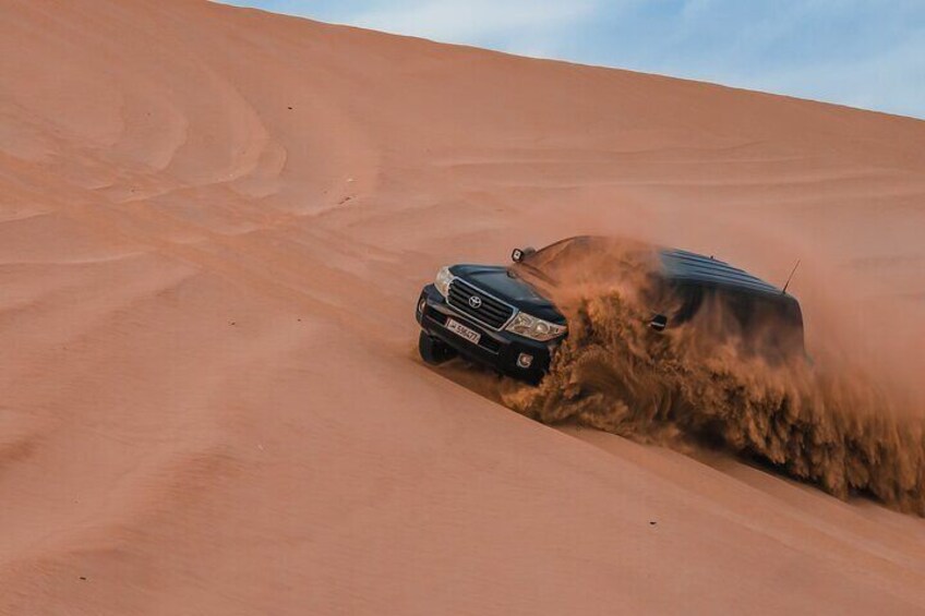 A vehicle driving on a sandy dune. 3