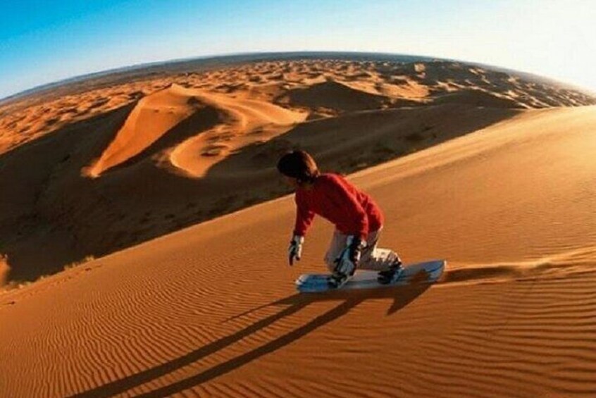 A person snowboarding on a sand dune. 5