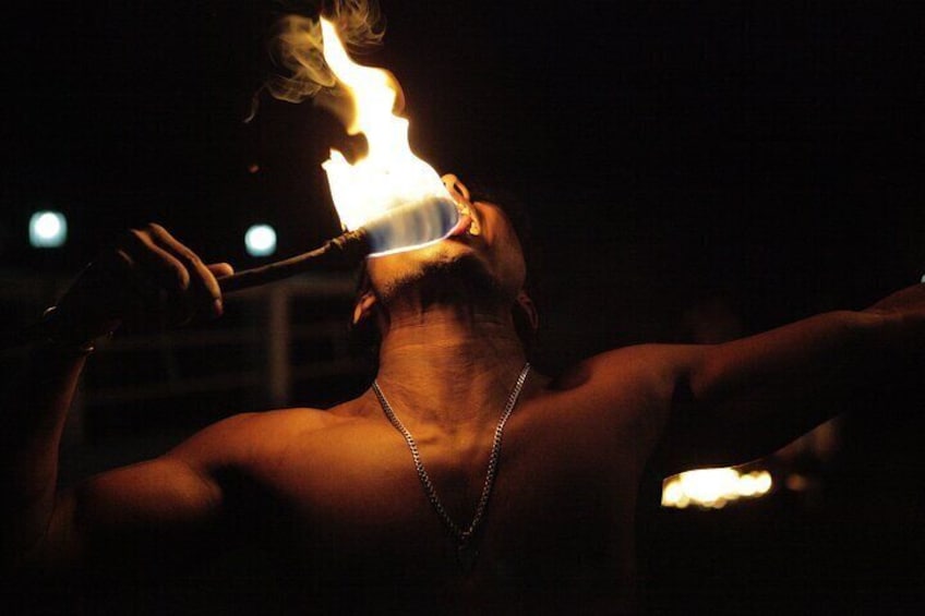 A person performing fire breathing with a torch. 4