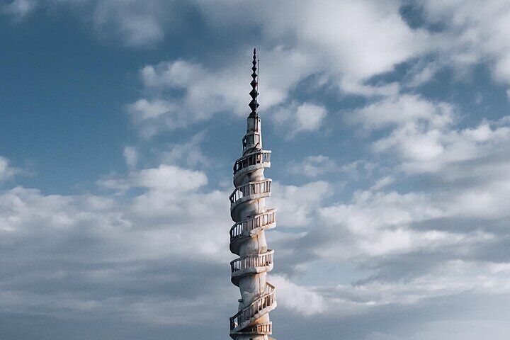 A spiral tower with balconies against a cloudy sky. 5