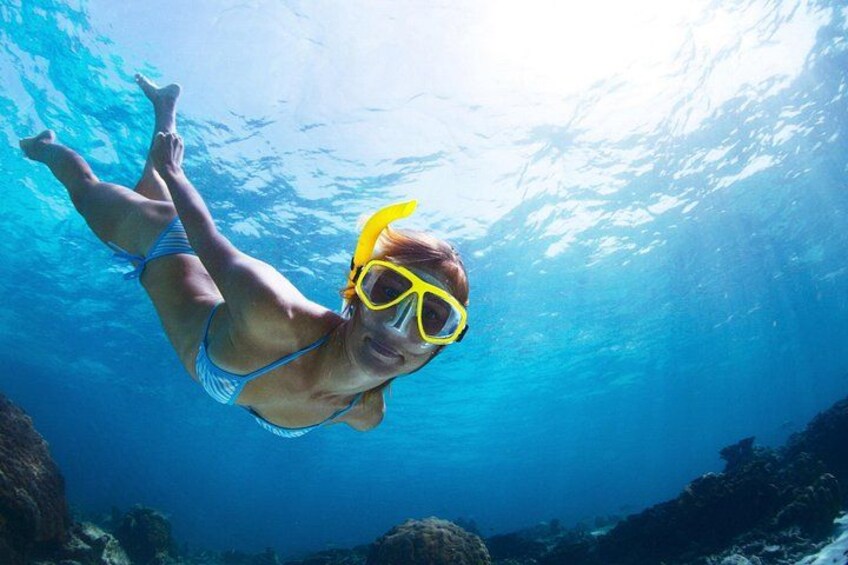 A person swimming underwater wearing a snorkel and goggles. 4