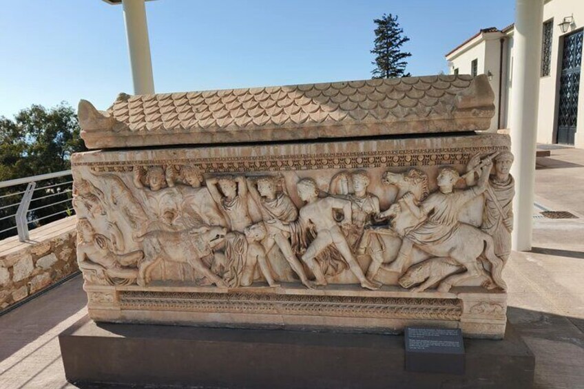 A stone sarcophagus with detailed carvings of figures and animals. 5