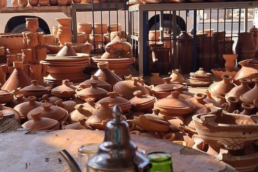 A variety of clay pots and pottery items displayed on a table and in a rack. 4