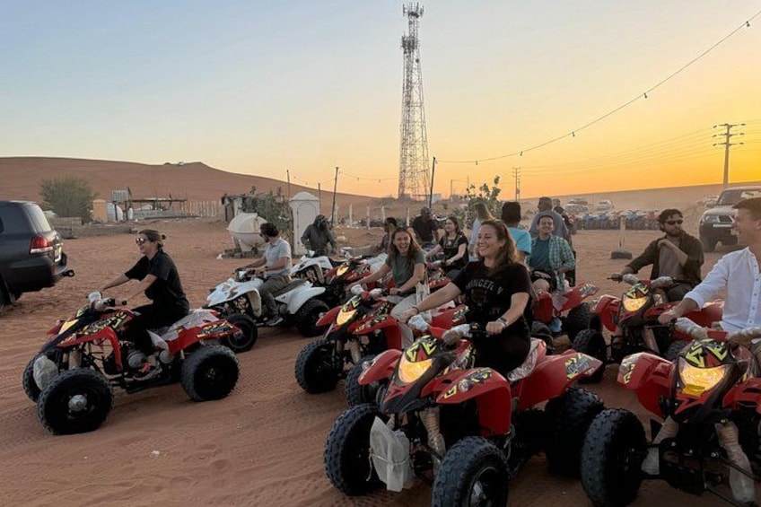 Een groep mensen op quadbikes in een woestijnlandschap, onder een heldere lucht. 3